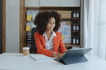 African American businesswoman working at office workplace, Female coworkers discussing project at laptop, professional at workplace. 