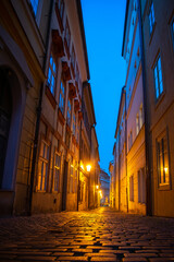 Romantic narrow street at Lesser town, Prague. Evening and street lamps on.
