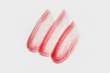 Smears of transparent shining lip gloss on a white background