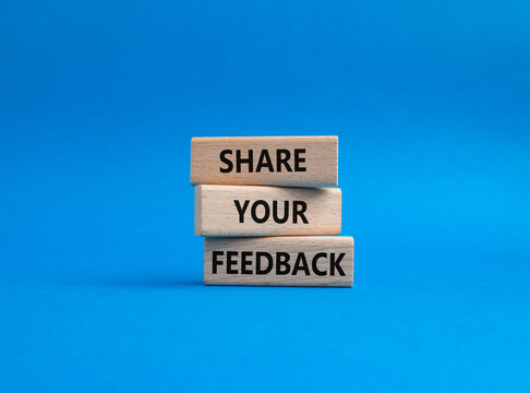 Feedback symbol. Concept word Share your feedback on wooden blocks. Beautiful blue background. Business and Ask for feedback concept. Copy space