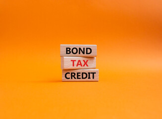 Bond Tax Credit symbol. Concept word Bond Tax Credit on wooden blocks. Beautiful orange background. Business and Bond Tax Credit concept. Copy space