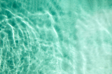 Abstract textured background, water waves in the pool with sun reflection, clear blue water