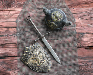 chain mail and sword on a wooden table