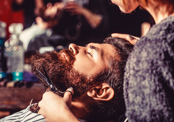 Man hairstylist. Beard man in barbershop. Hairstylist serving client at barber shop, bearded. Hairdresser, hair salon. Barber scissors, barber shop. Vintage barbershop, shaving