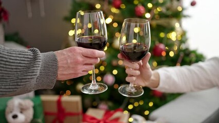 Two men couple celebrating christmas toasting with wine at home