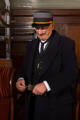Vintage train conductor punching ticket
