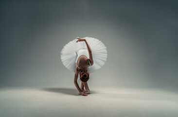 young ballerina bowing on a white background.