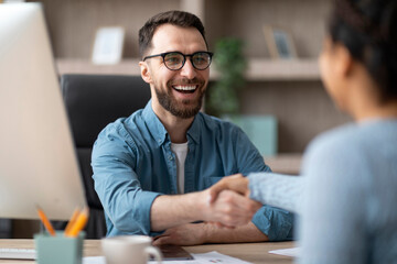 Partnership. Smiling Male Entrepreneur Giving Hand For Handshake To Female In Office