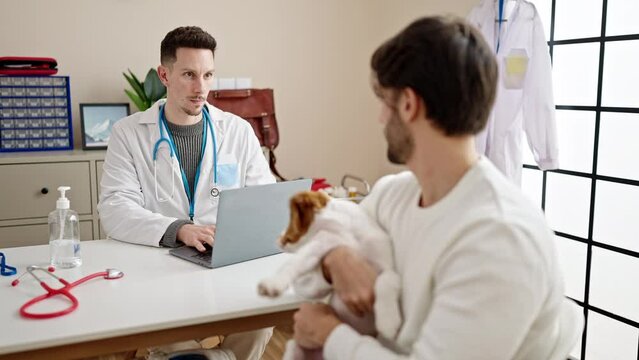 Two men having veterinarian consultation using laptop at veterinary clinic