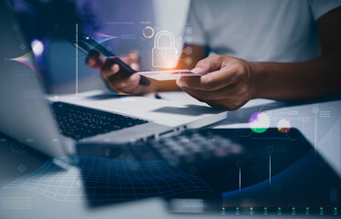 Business hands holding a credit card with mobile phone and laptop computer and Internet network security interface icons.