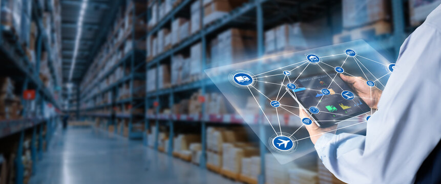 Smart Warehouse,Inventory management system concept.Manager using digital tablet,showing warehouse software management dashboard on blurred warehouse as background
