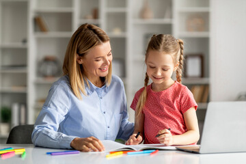 Fototapeta premium Doing Homework Together. Loving Young Mother Helping Her Little Daughter With Study