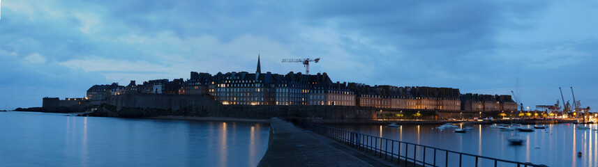 Fototapeta na wymiar Panoramic night view of walled city Saint-Malo with St Vincent Cathedral, famous port city of Privateers is known as city corsaire, Brittany.