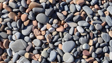 Stones of various sizes and colors on the edge of a sea. close-up.