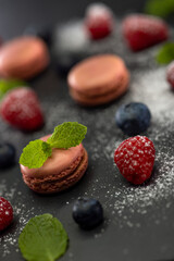 macaroons of different colors on a black background