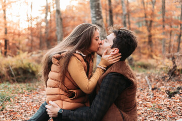 Young couple having loving time in the forest, kissing