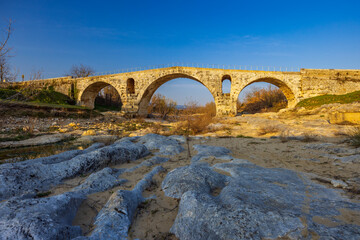 Fototapeta na wymiar Pont Julien, roman stone arch bridge over Calavon river, Provence, France