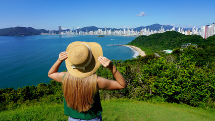 Vacation in Brazil. Panoramic view of traveler girl on viewpoint enjoying Balneario Camboriu...