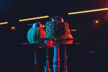 Red shisha hookah with smoke and red sparks on wood table brick, art background. Shisha Concept.