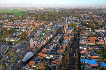 Fototapeta na wymiar Aerial drone photo of the town center of Voorschoten in Zuid-Holland, the Netherlands. There is a church and a shopping street. 