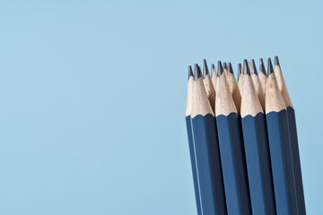 Bundle of blue Pencils on blue. Back to School or drawing and creativity concept. Office supply. Copy space. Side view close up