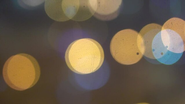 the lights outside the window are blurring, color lights, it's snowing, video footage