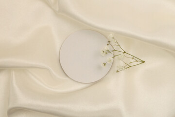 Beige white pearl wave silk fabric with circle frame card. Abstract texture copy space background.