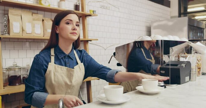 Woman, barista and serving coffee at cafe on counter ringing service bell for customer or waiter. Female person or waitress giving caffeine beverage, latte or espresso for order at restaurant or shop