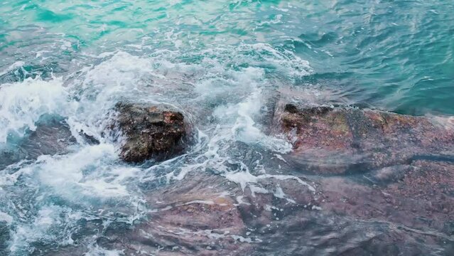 Rocky reefs and breaking waves of cliffs of sea coast. Breathtaking time-lapse top view of azure ocean and giant waves crashing against splashing rocky cliff. wanderlust concept