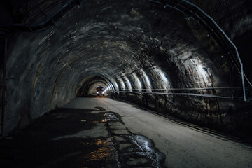 Naklejka premium Bus inside old underground road tunnel inside mountain