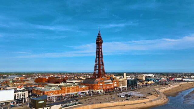 Aerial footage,of the famous Blackpool Tower and beach from the sky on a beautiful Summers day on one of Great Britains most popular holiday destinations, tourist attractions by the sea