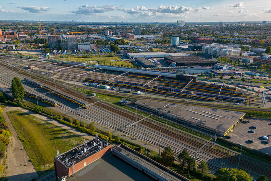 This aerial drone photo shows a marshalling yard in Den Haag, the Netherlands. There are many railway tracks and trains. 