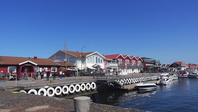 Hönö harbour with promenade and restaurants. People walking.