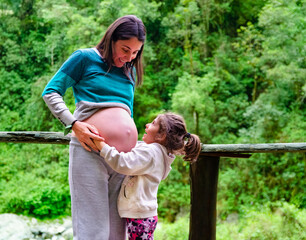 "Looking to the future: Mother and daughter celebrating the arrival of a new member of the family"