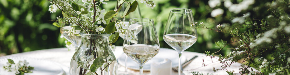 Rustic elegant eco friendly zero waste trendy wedding reception table decor with fresh spring apple cherry flowers in bloom. Beautiful marriage decoration, holiday outdoors in the family garden banner