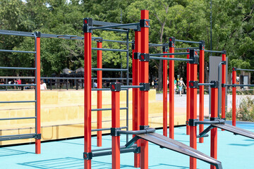 Fototapeta na wymiar Sports ground with horizontal bars and other exercise equipment in open air sport zone in the city. Modern sports empty simulators for sports near the house. Street sports ground in park. 