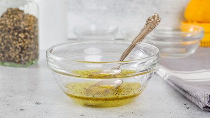 Lemon-olive oil salad dressing in a glass bowl close-up