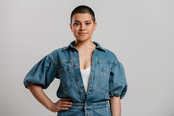 Beautiful young short hair woman in denim clothes looking at camera against grey background