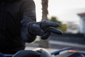 Close-up of a biker's hands showing the hand gestore of salute, the V gesture - obrazy, fototapety, plakaty
