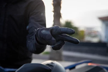 Afwasbaar Fotobehang Motorfiets Close-up of a biker's hands showing the hand gestore of salute, the V gesture
