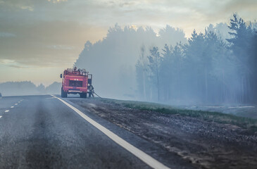 Fire truck and firefighter put out fire in the forest