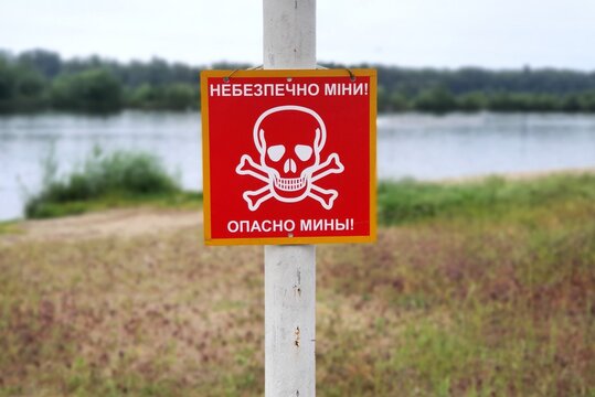 Russia war against Ukraine, Ukrainian war. Red sign skull and bones, danger sign from mines, minefields. inscription in Ukrainian, Russian - Dangerous mines