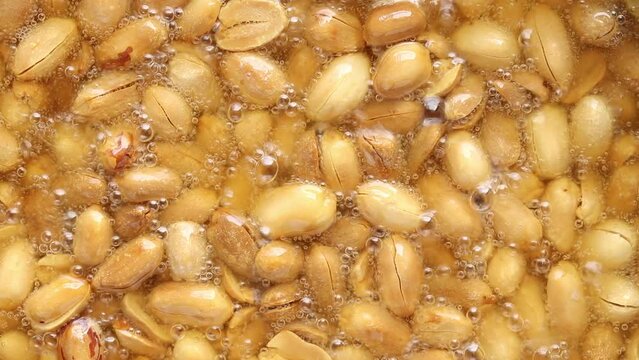 peeled peanuts in boiling oil. vegan and vegetarian food