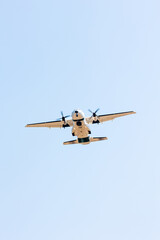 bottom view of a military cargo plane in action over the blue sky at the Gijon air show festival on a warm summer day