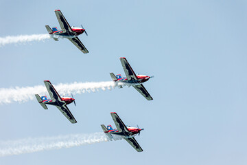 Rotor planes team flying in formation over the blue sky with color steles on a summer day at Gijon air show festival