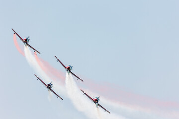 Airplanes squadron flying in formation over the blue sky with color steles on a summer day at Gijon air show festival