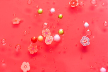 Colorful gel texture, clear skincare cream with bubbles and decorative figurines background, transparent beauty serum, colored cosmetic product close up