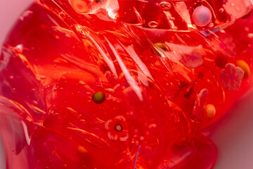 Colorful gel texture, clear skincare cream with bubbles and decorative figurines background,...