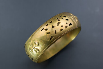 Huge old gold bangle bracelet, unique vintage jewelry background, bold jewelry concept, promotional photo for an online jewellery store