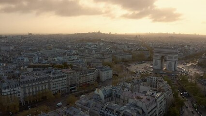 Aerial above Paris old town buildings and Arc de Triumph. Paris skyline panorama, morning warm orange light